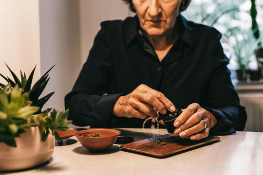 Unrecognizable Senior Citizen Putting CBD Cannabis in Grinder