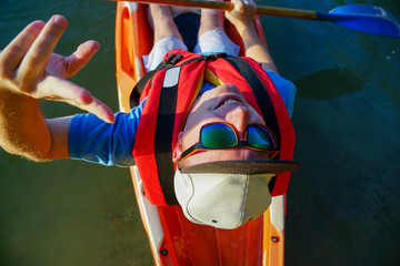 a kayaker with glasses holds a paddle in his hands and looks up
