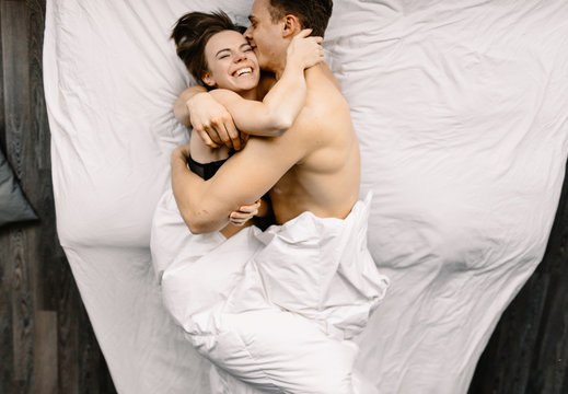 happy couple cuddling in bed