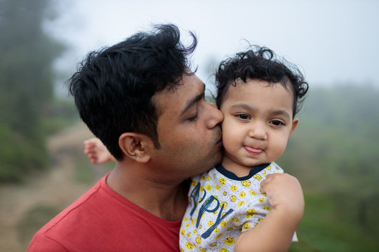 Father kissing her baby girl outdoors