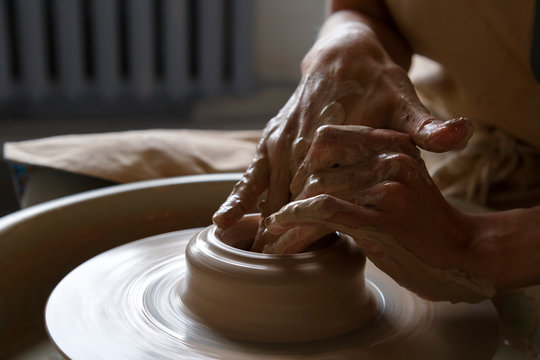 Clay modeling process on throwing wheel at workshop