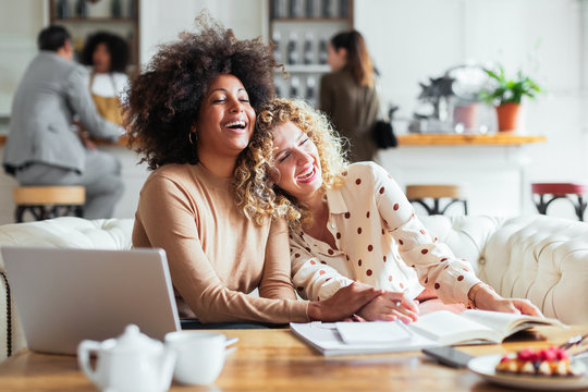 Laughing freelancers working in restaurant