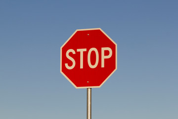 Stop sign against clear blue sky during sunrise or sunset. Business concept with copy space.