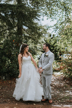 Happy Bride and Groom Holding Hands in Woods