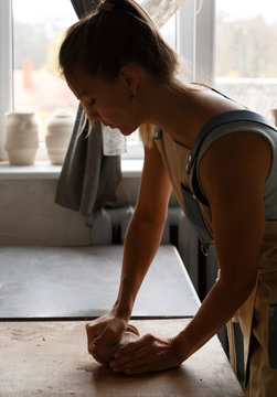 Female master preparing clay at studio