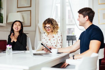 Delighted multiethnic managers working in cafe