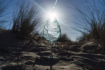 Bebida azul vertida en copa de balon en la playa © MiguelAngelJunquera