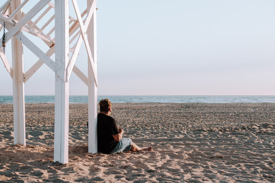 Hombre tocando el ukelele en la playa 