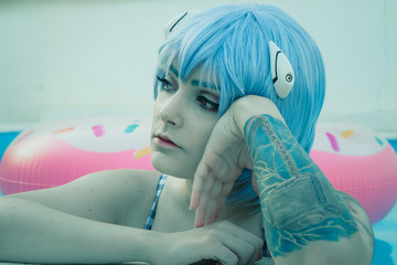 Chica con pelo azul disfrutando de la piscina en verano