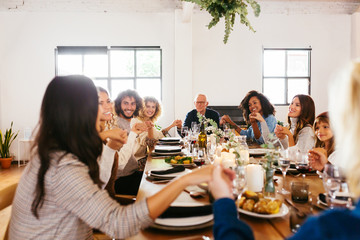 Diverse family praying at table