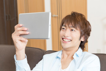 タブレットPCを見る男性