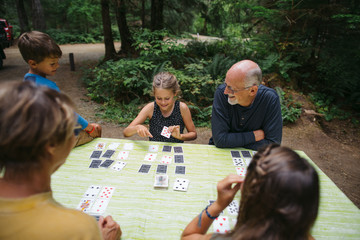 Fun loving grandparents playing card games with grandkids on cam