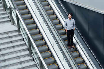 Businessman standing on escalator
