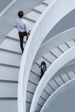 Businessman and businesswoman walking on office stairs