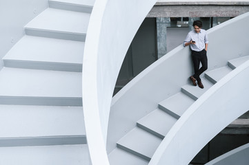 Businessman using smartphone on stairs