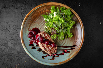 Juicy tasty beef tenderloin steak with cherry jam and green salad. Hearty meat dish