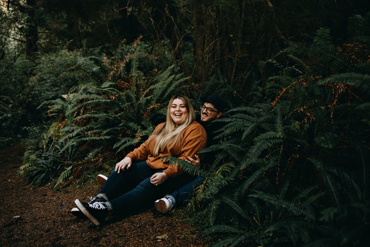 Happy Couple Laughing, Sitting in Ferns