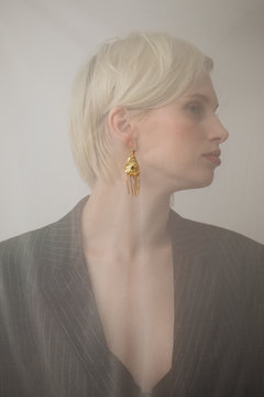 Blond woman demonstrating golden earring