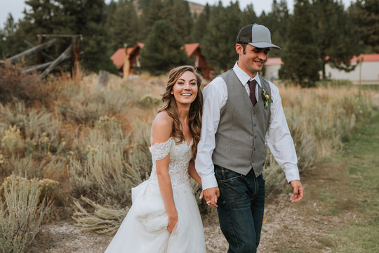 Happy Bride and Groom Walking in Field