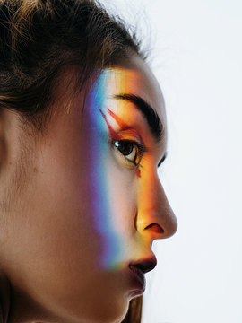 Ethnic model with rainbow ray on face