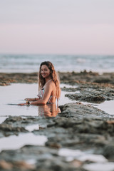 Chica disfrutando de la playa en bikini durante la puesta de sol