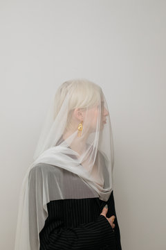 Blond woman demonstrating golden earring