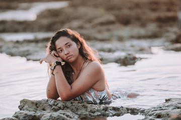 Chica disfrutando de la playa en bikini durante la puesta de sol