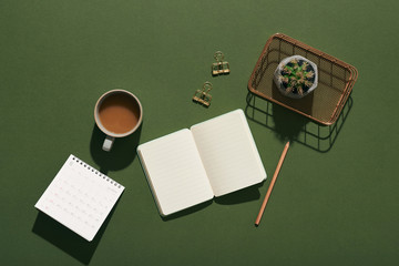 Stylish workspace with notebook, cup of coffee, paper blank, pencils. Business concept. Flat lay, top view.