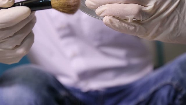 Criminologist police chemist takes fingerprints from ashtray.