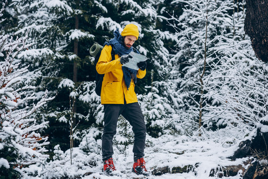 Boy traveling to mountain and holding map in hand.
