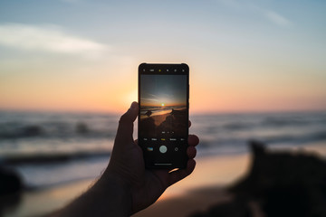 Paisaje de playa de la cala de roche a traves de un smartphone - obrazy, fototapety, plakaty