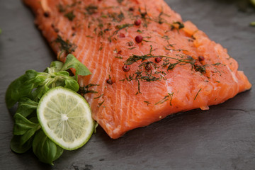 a piece of lightly salted salmon on a black background close up