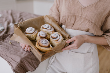 Woman holding cinnamon rolls