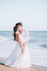 Fototapeta na wymiar Novios en la playa disfrutando en el dia de boda