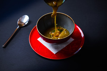 Bowel of beef broth soup in rustic clay bowel