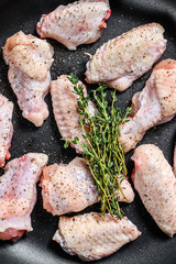 Marinated chicken wings with spices and herbs in a pan. Gray background. Top view