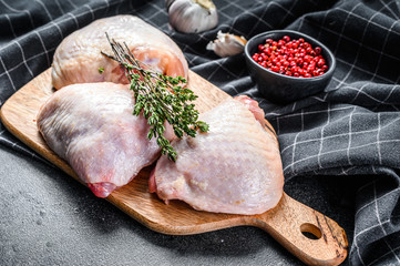 Fototapeta Fresh chicken thigh with skin on cutting board, organic meat. Black background. Top view obraz