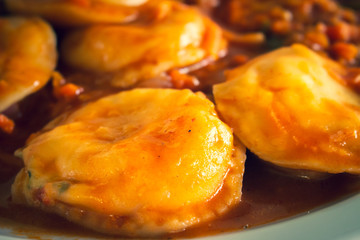 Italian stuffed pasta bathed in red tomato sauce. Tasty Italian artisan food.