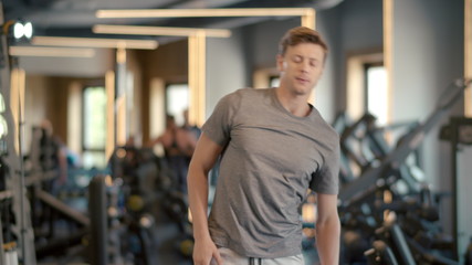 Fototapeta premium Serious fitness man warming up in sport club. Sportsman doing exercises at gym