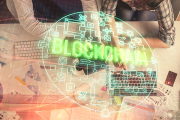 Double exposure of man and woman working together and crypto theme hologram drawing. Computer background. Blockchain concept. Top View.