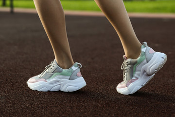 Fototapeta na wymiar beautiful sports sneakers on women's legs.