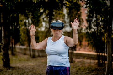 Senior woman doing workout with virtual reality headset