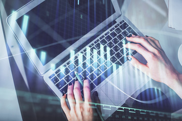 Double exposure of woman hands working on computer and forex chart hologram drawing. Top View. Financial analysis concept.