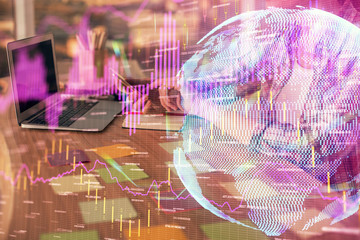 Double exposure of businesswoman hands typing on computer and forex graph hologram drawing....