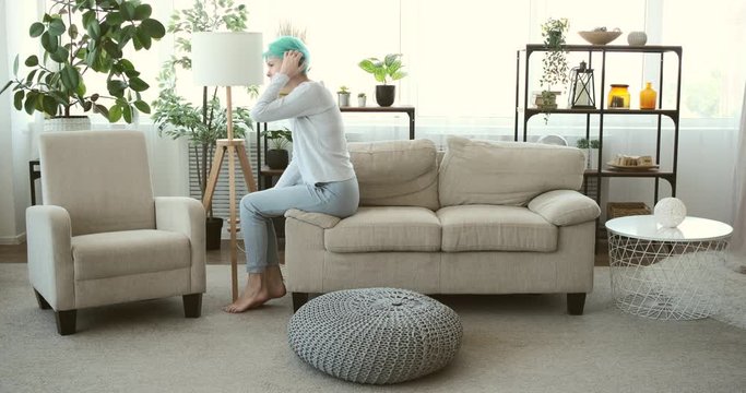 Highly depressed woman feeling uncomfortable and falling back on sofa at home