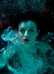 woman underwater posing with bubbles