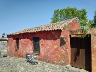Una casa roja, con la tradicional arquitectura colonial con techo de teja, que se encuentra en...