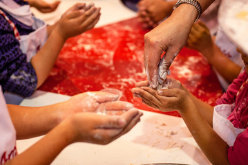 Niños jugando con harina para hacer pizzas
