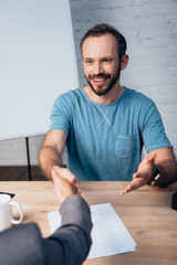 selective focus of bearded man gesturing while shaking hands with lawyer