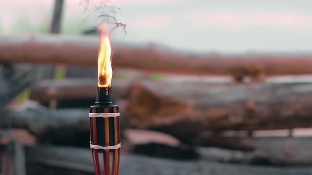 Tropical Bambo Torch Burning in the Beach at Summer Evening. Decorative Candle Has a Massive Orange Flame Using Oil Fuel or Kerosene. Static Shot